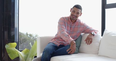 Man in Casual Relaxed Style Sitting on Sofa at Home