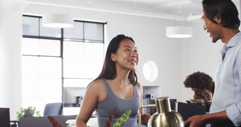 Multicultural colleagues discussing ideas in modern office environment
