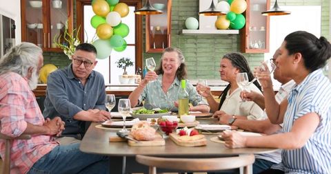 Cheerful Senior Friends Toasting at Group Dinner Gathering