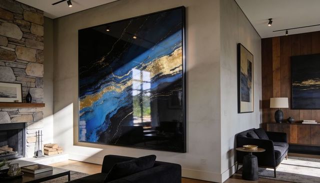 Glossy blue and gold abstract canvas reflecting window light in contemporary living room