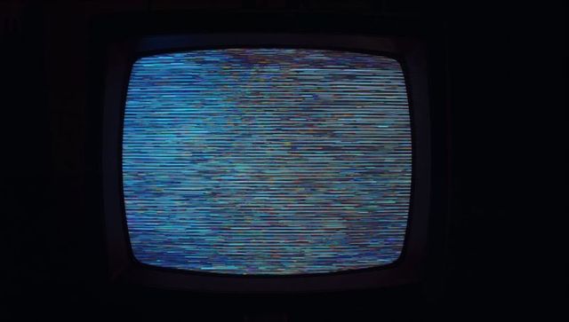 Vintage CRT Television With Retro Static Screen in Dimly Lit Room