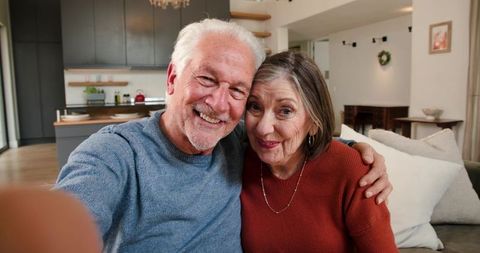 Senior Couple Smiling for a Selfie in Cozy Home Setting