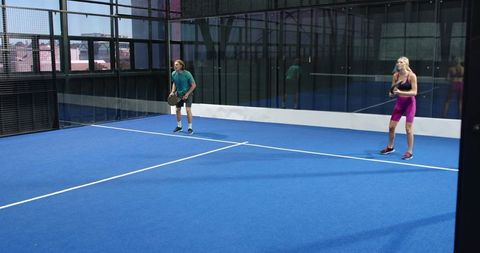 Couple playing padel on urban synthetic court