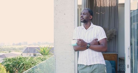 Relaxed Man Holding Mug on City Balcony Admiring Peaceful View