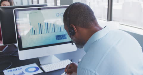 Business Professional Analyzing Data with Headset in Modern Office