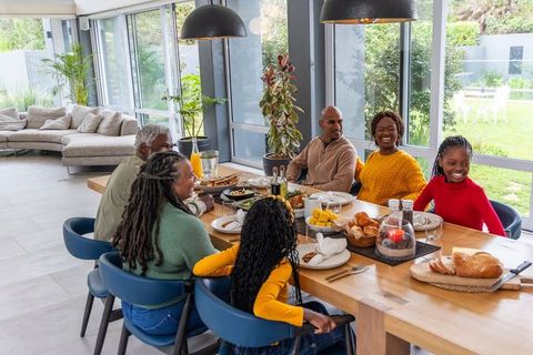 Multigenerational african american family enjoying meal in modern open-plan dining room
