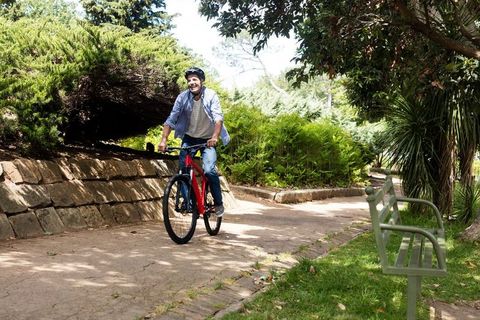 Senior Man Enjoying Leisurely Bicycle Ride in Scenic Park