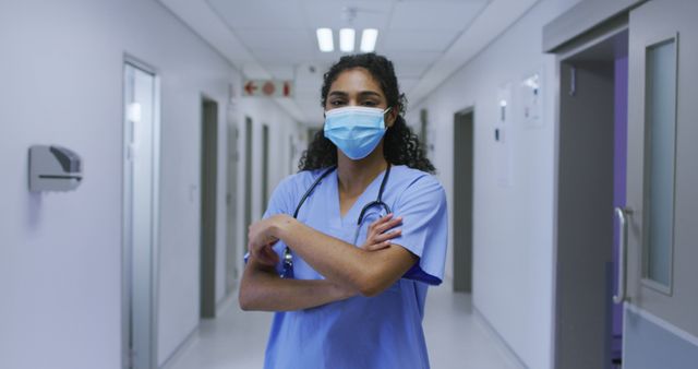 Portrait of asian female doctor wearing face mask and scrubs standing in hospital corridor. medicine, health and healthcare services during coronavirus covid 19 pandemic.