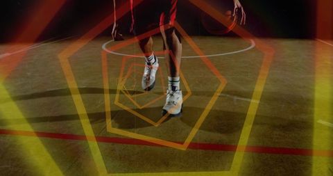 Dynamic basketball dribble under spotlight with geometric light overlay and hardwood court