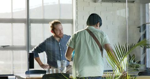Colleagues discussing strategy in sunlit modern office