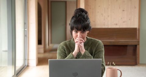 Young Woman Focused on Laptop in Cozy Home Office Environment
