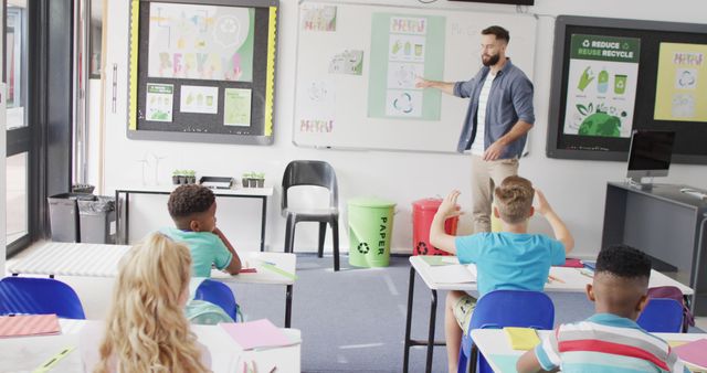 A teacher is standing in front of the classroom pointing at recycling diagrams on the board while students are sitting attentively at their desks. Perfect for illustrating educational materials, environmental awareness campaigns, and efforts in eco-friendly teaching. Useful for blogs, articles, and educational content related to sustainability and innovative teaching methods.