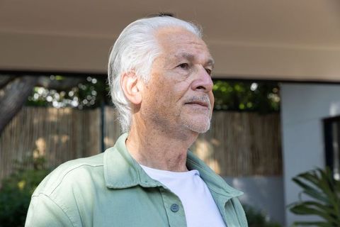 Senior Man Reflecting Outdoors Under Patio Awning