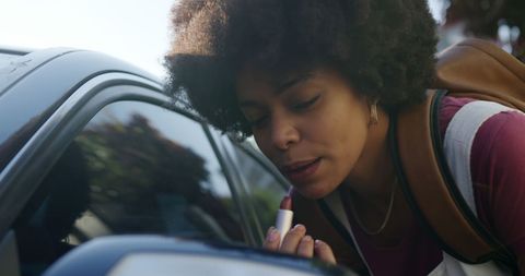 stylish young woman applying lipstick with car mirror - Download Free Stock Images Pikwizard.com