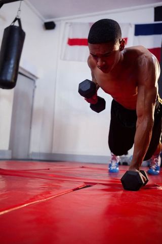 Strong Athlete Doing Dumbbell Push-Up in Boxing Gym for Cardio Fitness