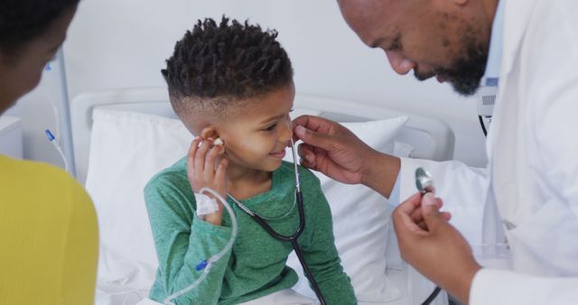 African american male doctor examining child patient, using stethoscope at hospital - Download Free Stock Photos Pikwizard.com