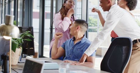 Excited business team celebrating success in modern office