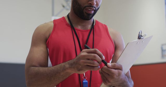 Gym Instructor in Red Tank Top Taking Notes on Clipboard at Gym - Download Free Stock Images Pikwizard.com