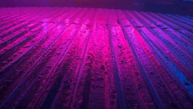 Neon Lit Corrugated Metal Rooftop with Reflective Water Droplets
