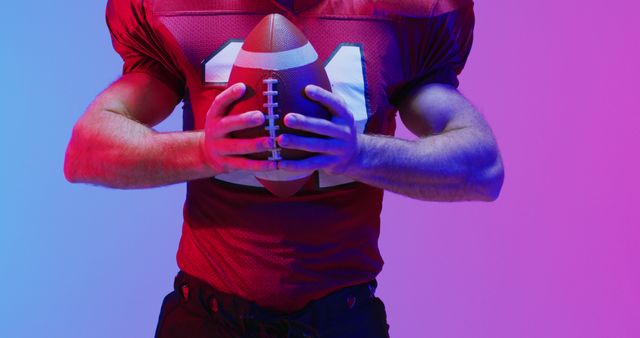 Image of portrait of caucasian american football player with ball over neon purple background. American football, sports and competition concept.
