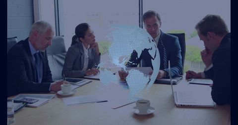Executive team reviewing global strategy in boardroom with digital globe overlay