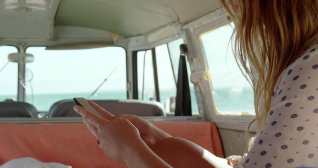 Woman using smartphone inside camper van near beach - Download Free Stock Images Pikwizard.com