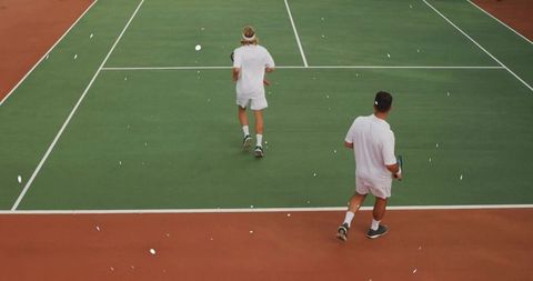 Tennis Players Practicing on Green Hard Court