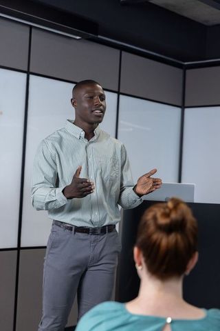Confident presenter engaging audience in modern conference room