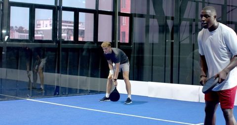 Athletic Duo Competing in Padel on Urban Glass Court
