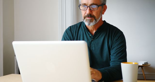 Mature Man Working on Laptop in Home Office Setting - Download Free Stock Images Pikwizard.com