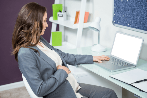 Pregnant businesswoman using transparent laptop in home office