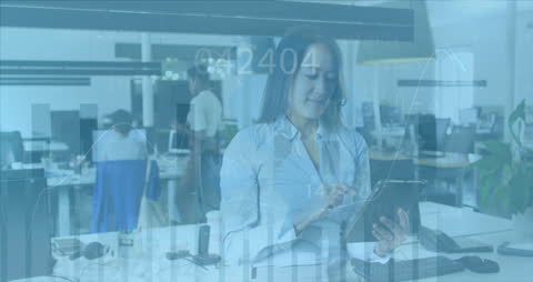 Woman Analyzing Financial Data on Tablet in Modern Office