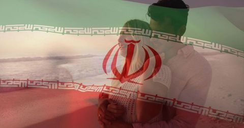 Embracing couple standing on beach at sunset with translucent iranian flag overlay