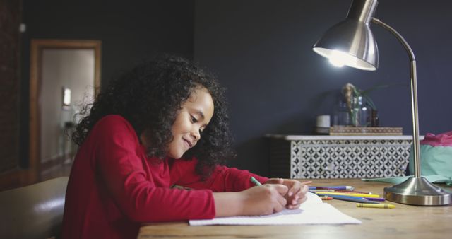 Young Girl Joyfully Writing with Colored Pencils at Home Desk - Download Free Stock Images Pikwizard.com