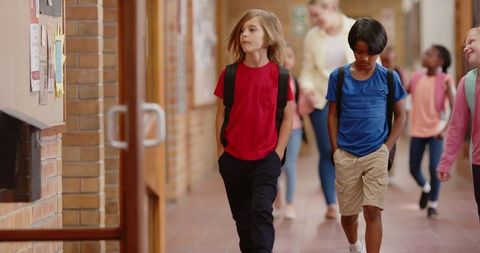 Diverse Children Walking Through School Hallway with Teacher