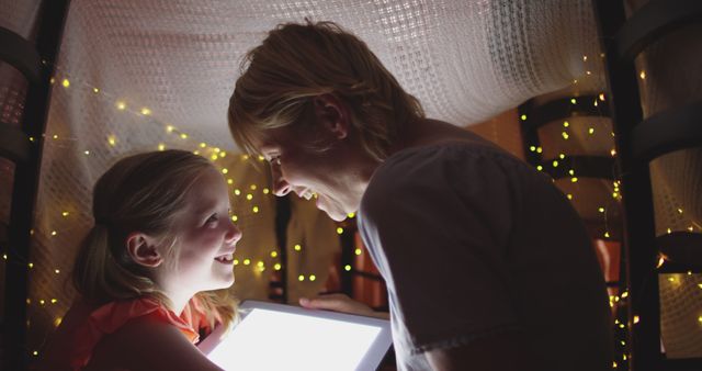 Mother and Daughter Sharing Digital Tablet Under Blanket Fort with Fairy Lights - Download Free Stock Images Pikwizard.com