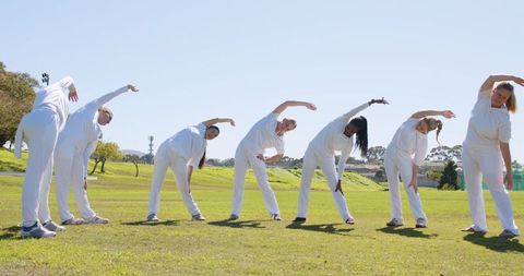 Diverse Women Exercising Outdoors in Synchrony in White Activewear