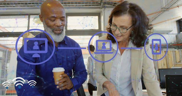 Image of network of digital icons over diverse man and woman discussing over a plan at office. Global networking and business technology concept