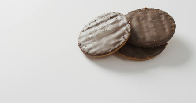 Three chocolate-dipped biscuits together on white background. Great for use in food blogs, dessert recipe features, snack advertisements, and menus.