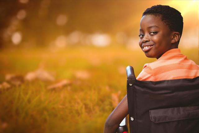 Digital composite of Boy smiling while sitting in wheelchair at park