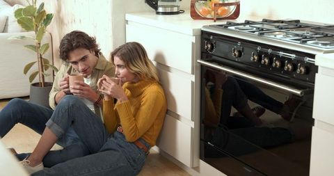 Young Couple Relaxing in Modern Kitchen Over Coffee