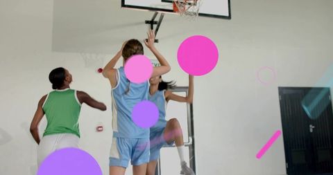 Jumping player reaching for rim during fast break, defender contesting shot in indoor gym