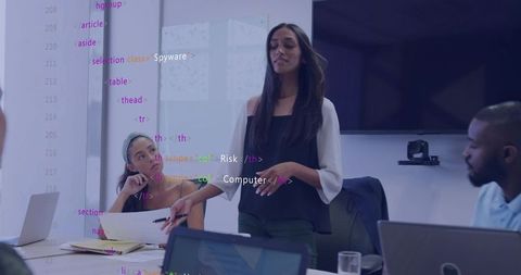 Businesswoman presenting to team with code overlay in modern conference room