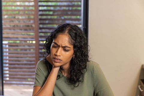 Focused Indian Woman Studying at Home by Window