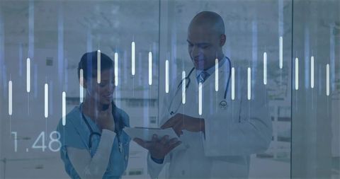 Doctors Reviewing Digital Data on Tablet in Hospital Corridor