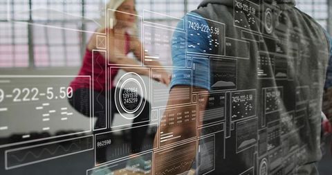 Man touching transparent data dashboard revealing interactive analytics and team metrics