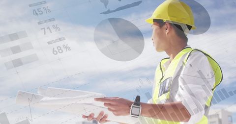 Asian Architect Analyzing Building Plans over Economic Graphs - Download Free Stock Images Pikwizard.com