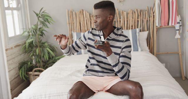 Man Recording on Smartphone Seated on Bed in Cozy Bedroom - Download Free Stock Images Pikwizard.com