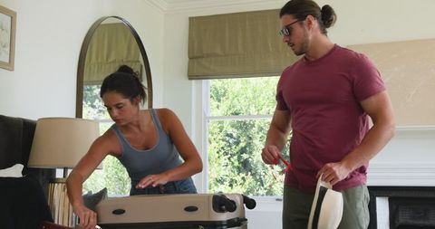 Couple Packing Suitcase at Home for a Special Celebration