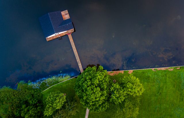 Aerial View of Lakeside Boathouse and Lush Greenery - Download Free Stock Images Pikwizard.com